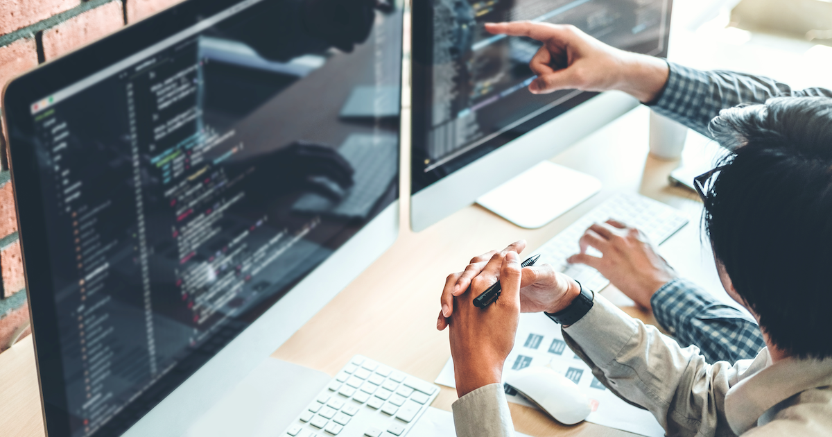 2 business owners researching their cyber liability insurance options in front of a computer