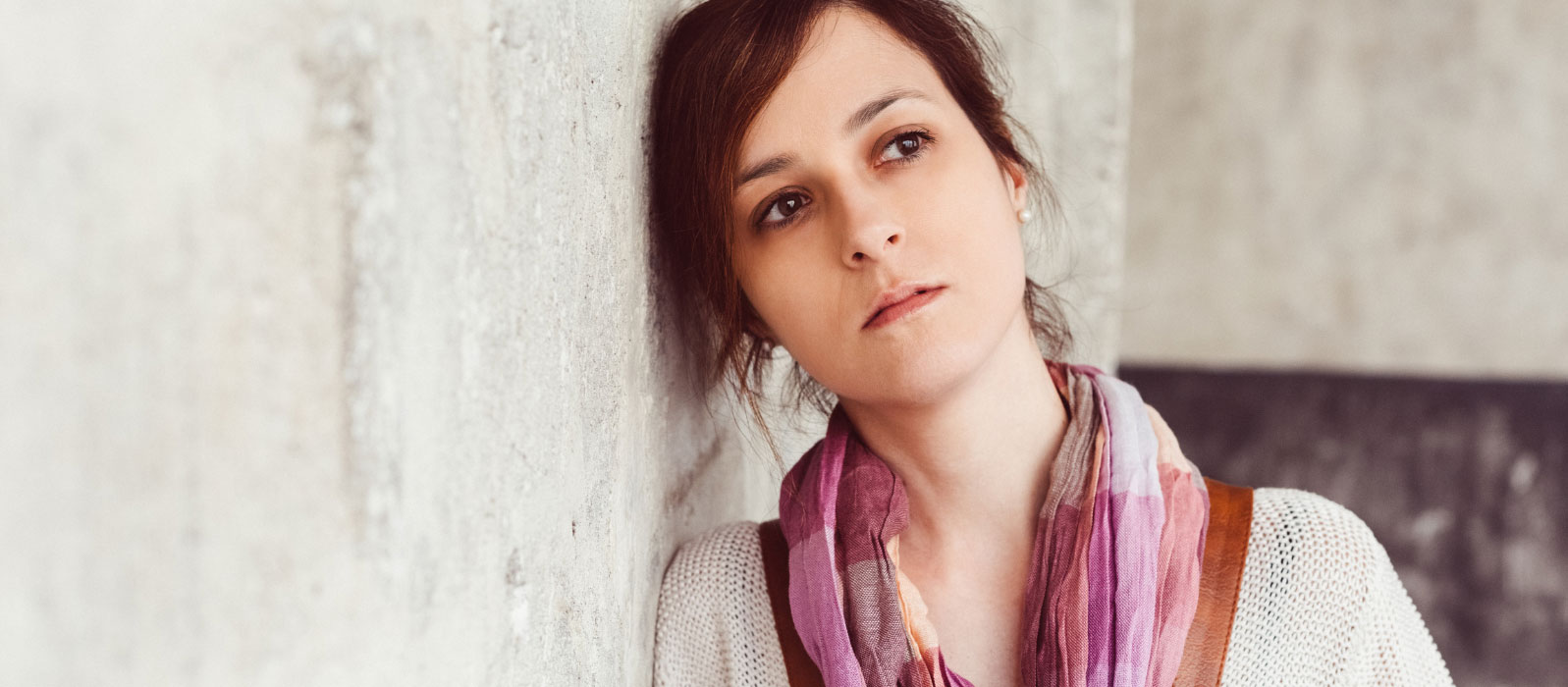 a woman leaning against wall, wondering how she can turn her mood around